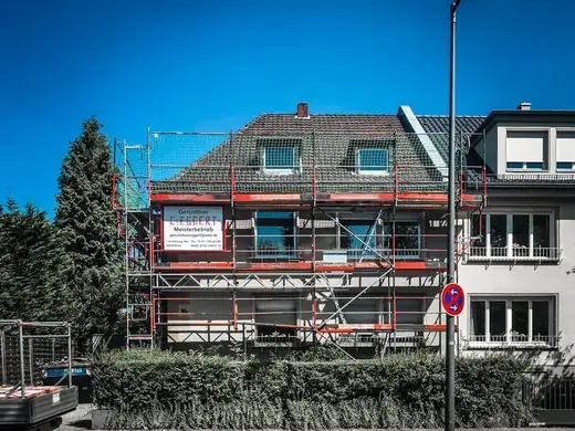 Ein Haus wird umgebaut, an der Seite steht ein Gerüst.