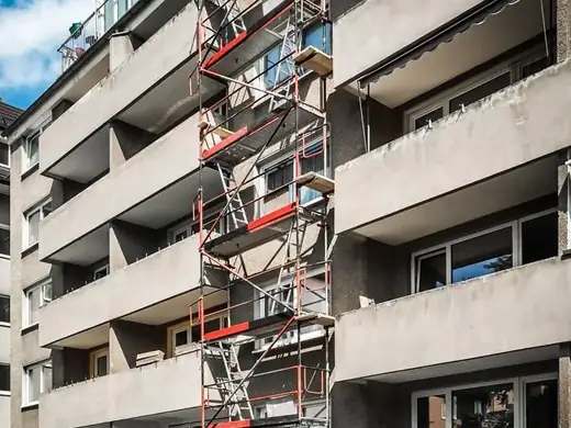 Ein großes Wohnhaus mit Gerüst an der Seite